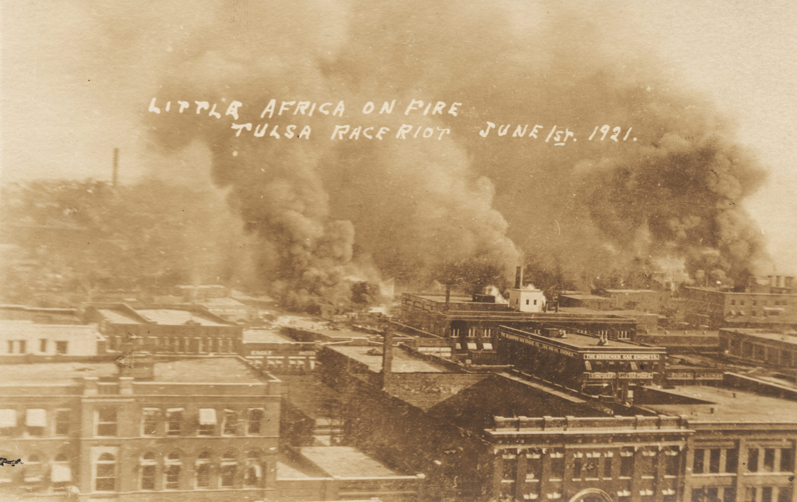 A postcard showing the scene from the roof of the Hotel Tulsa on 3rd St. between Boston Ave. and Cincinnati Ave.. The first row of buildings is along 2nd St. The smoke cloud on the left (Cincinnati Ave. and the Frisco Tracks) is identified in the Tulsa Tribune version of this photo as being where the fire started. Title is taken from the writing on the face of the postcard.