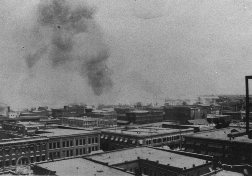 A photographic reproduction of a photo taken overlooking the intersection of 2nd St. and Cincinnati Ave. from the Hotel Tulsa, looking towards the Greenwood District. "G1 of 28" written on back.