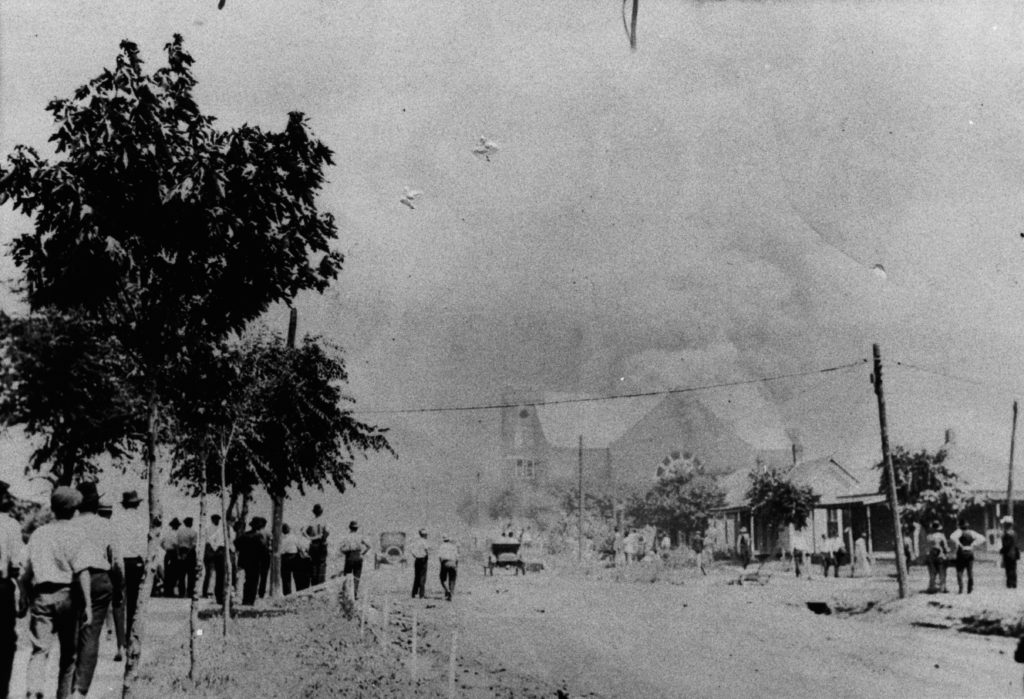 A photographic reproduction of a photo taken of the crowd looking North up Elgin Ave. from Davenport St, watching the Mt. Zion Baptist Church burn. Title supplied by cataloger from writing on the front. "G12 of 28" written on back. Note on back: "Photograph no. 25 in the Clark Blue collection in the Western History Collection, University of Oklahoma..."
