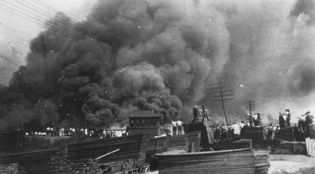 A photographic reproduction of a photo taken ofTulsa burning near railroad tracks. "G15 of 28" written on back. Title written on back.