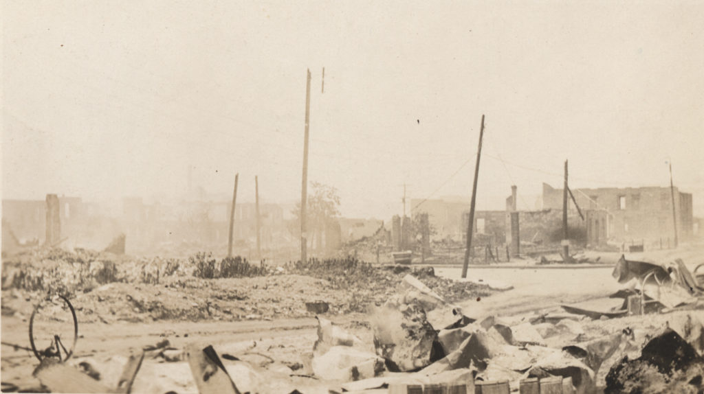 Telephone poles rising up above the ruined remains of buildings after the Tulsa Race Massacre.