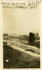 Vertical photograph of burned ruins of a house. There is an "X" written on a certain part of the photograph. Writing along the top reads "Part of Dark Town's 'ELITE' Section, 'Standpipe Hill.'"