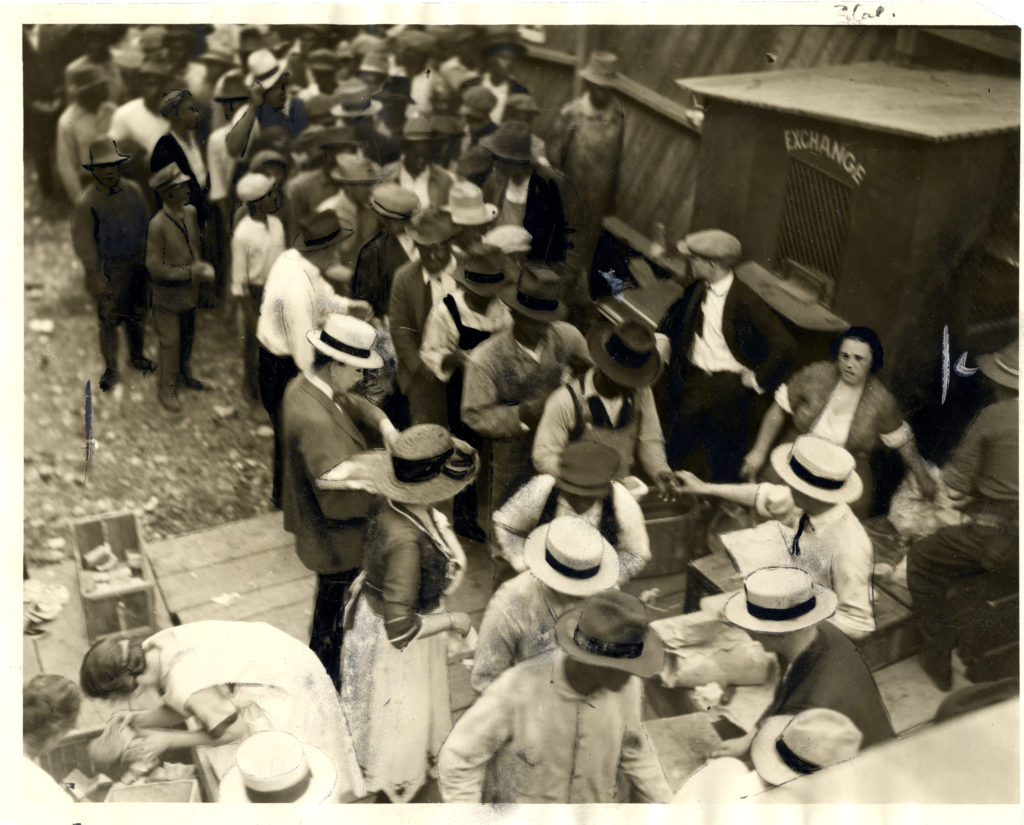 Overhead photograph of African-American men lined up to receive food at the McNulty baseball park.